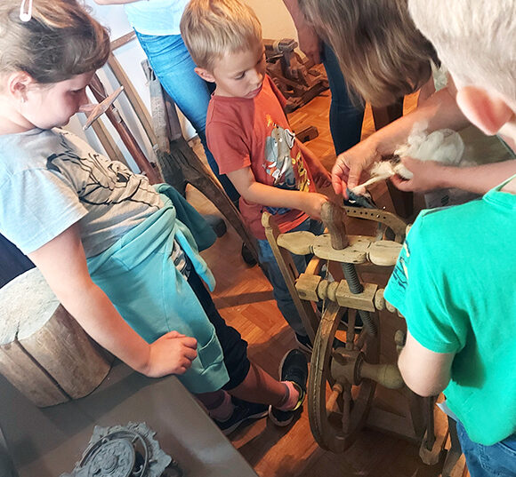 Wie funktioniert ein Spinnrad? Kinder erforschen alte Gerätschaften beim Ferienspiel 2025